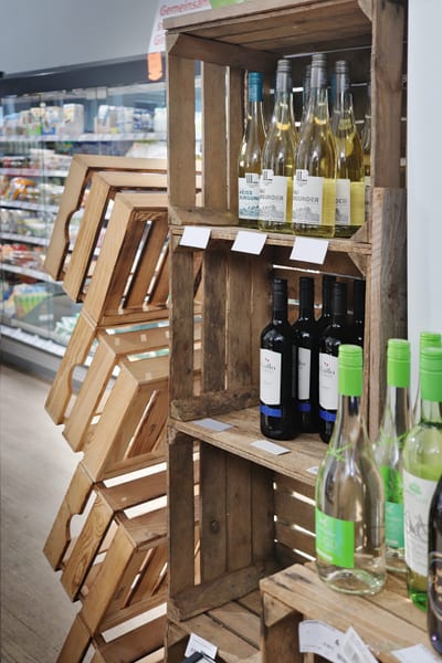 Weißwein und Rotwein in einem Regal aus Holzkisten