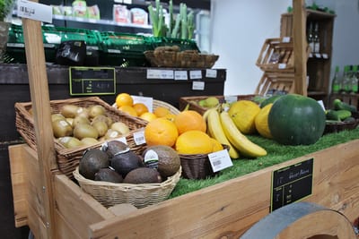 Kiwis, Avocados, Orangen, Bananen und Melonen in Körben auf dem Marktkarren